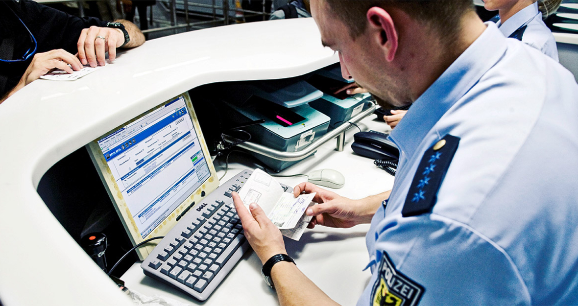 Bundespolizist überprüft einen Ausweis