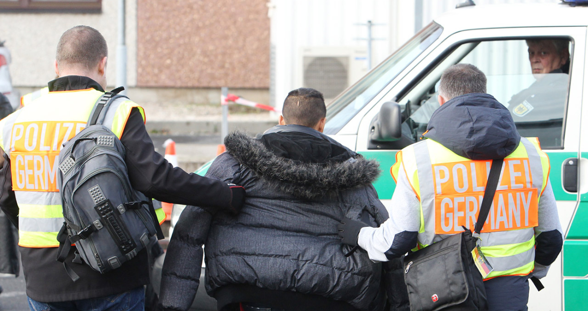 Polizisten begleiten einen straffällig gewordenen Asylbewerber