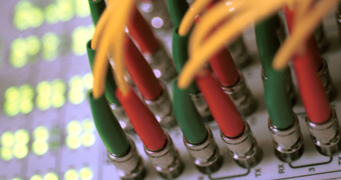 Internet: Blick auf zentralen Verteiler-Knoten eines IT-Netzwerkes im Ethernet-Standard mit Kabeln und Kontrolllampen