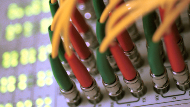 Internet: Blick auf zentralen Verteiler-Knoten eines IT-Netzwerkes im Ethernet-Standard mit Kabeln und Kontrolllampen